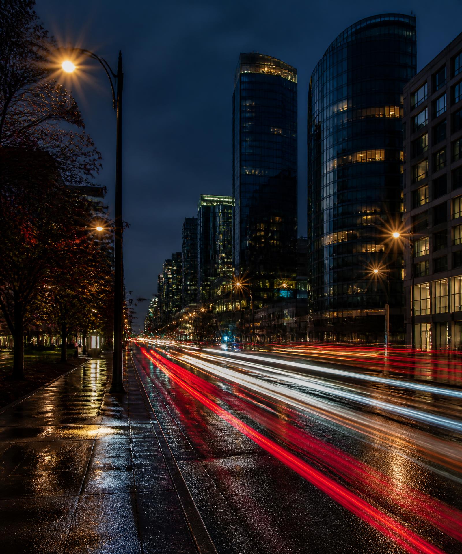Long-exposure night street with light trails across a Kiaro delivery zone